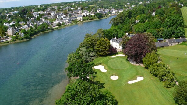 An aerial view of a golf course with a lake, surrounded by residential buildings and dense greenery. - Discovering the Breton Riviera- House for 8 (La Forêt-Fouesnant)