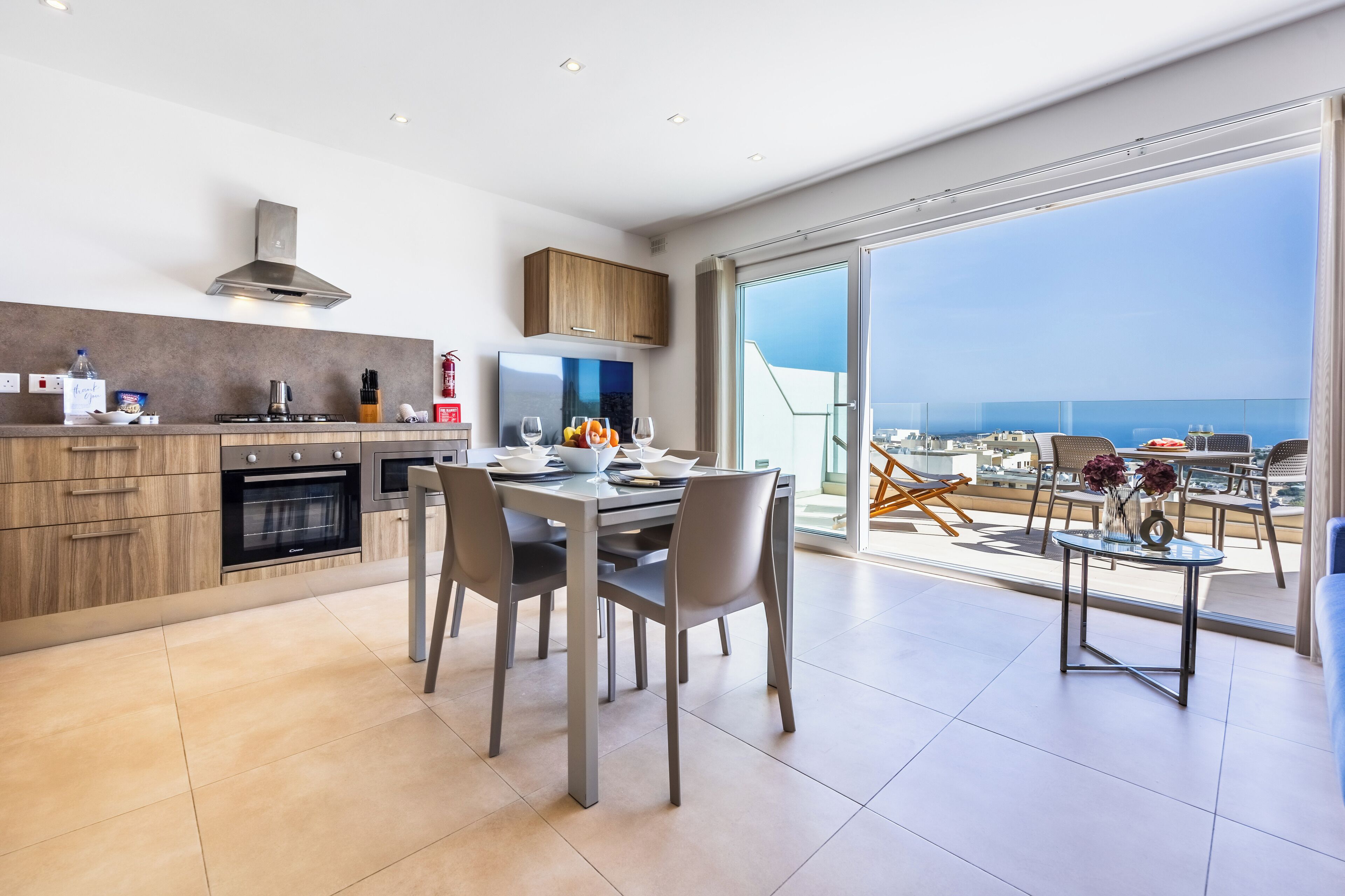 Una cucina moderna con zona pranzo e un balcone vista città.