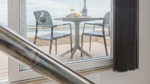 Una habitación moderna con un ventanal grande con vista a la playa.