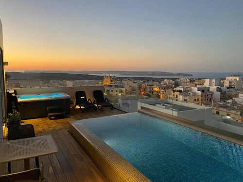 Luxury 2-bedroom duplex penthouse in Mellieħa 🌴✨ featuring a private pool, jacuzzi, sun deck, and stunning views of Comino and Gozo 🌊 Enjoy modern interiors, full amenities, and coin-operated AC ❄️💠