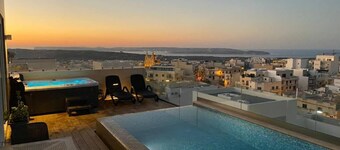 Luxury 2-bedroom duplex penthouse in Mellieħa 🌴✨ featuring a private pool, jacuzzi, sun deck, and stunning views of Comino and Gozo 🌊 Enjoy modern interiors, full amenities, and coin-operated AC ❄️💠