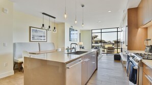 A modern kitchen with a central island, pendant lighting, and a view to the outside. - Lift Condo With Ski-in out w Village Access hot tub Fitness Center ski Rentals On-site (Park City)