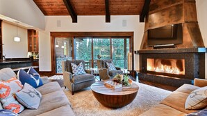 A modern living room with a fireplace, comfortable seating, and a view of the outdoors. - Chic Colony Ski-in Ski Out Villa Direct Access to Adventures at Park City Resort Hot Tub Gym (Park City)