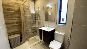 Ein modernes Badezimmer mit Dusche, Toilette und Waschbecken.