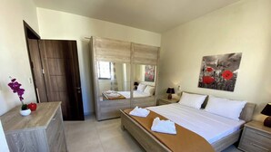 Ein Schlafzimmer mit einem großen Bett, einem Kleiderschrank, einem Nachttisch und einem Spiegel.