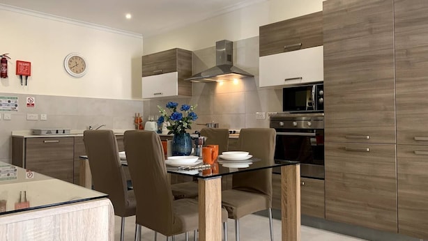 A modern kitchen with wooden cabinets, a stainless steel oven, and a microwave.