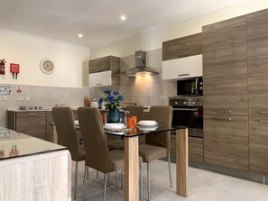 Een moderne keuken met houten kastjes, een RVS oven en een magnetron.