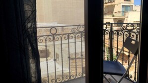 A balcony with a metal railing and a chair.