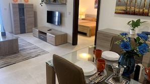 A modern living room with a TV, sofa, and dining area.
