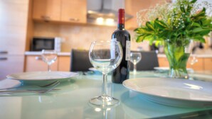 Una mesa de comedor con platos, cubiertos y una botella de vino.