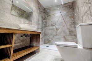 A modern bathroom with a marble shower, a wooden vanity, and a toilet. - Relax with the whole family at this peaceful place to stay (Il-Mellieħa)