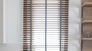 Eine moderne Küche mit integriertem Spülbecken, Holzschränken und einem Fenster mit Jalousien.