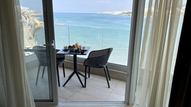 Ein Balkon mit Frühstückstisch und Blick auf die Küste.