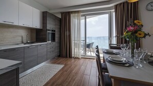 A modern kitchen with a dining area, large windows, and a view of the sea. - Kick back and relax in this calm, stylish space (San Pawl il-Baħar)