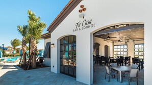 A bar and lounge named 'Tu Casa' with outdoor seating and a pool area. - Themed 8BR | Arcade | 2 Theaters | Pool & Spa (Kissimmee)