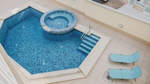 A swimming pool with a hot tub, lounge chairs, and a tiled deck area. - Escape to your dream coastal retreat in Mellieħa — a spacious, modern haven just steps from golden beaches. Relax, unwind, and soak up the island sunshine. (Il-Mellieħa)