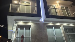 Ein mehrstöckiges Gebäude mit beleuchteten Fenstern und einer markanten vertikalen Lichtanlage.