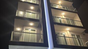 A multi-story building with illuminated windows and a prominent vertical light feature.