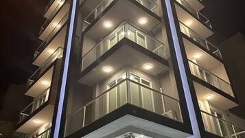 Ein mehrstöckiges Hotel mit modernem Design, mit Balkonen auf jeder Etage, einem Schild mit der Aufschrift 'Minerva Suites' und einem Verbotsschild für Fahrzeuge.