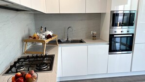 A modern kitchen with white cabinets, a gas stove, a microwave, and a double oven. - Take it easy and soak up the good life at this unique luxury penthouse, where sweeping sea views and your own rooftop pool make every moment feel unforgettable. (Il-Mellieħa)