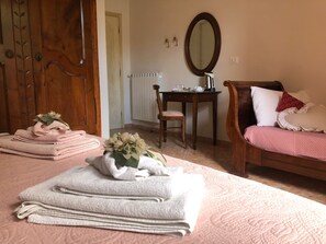 A bedroom with a bed, a desk, a chair, and a bathroom visible through an open door. - B&B Myosotis (Pisa)