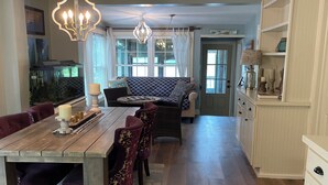 Ein geräumiger Essbereich mit Holztisch, gepolsterten Stühlen und einer Chandelier.