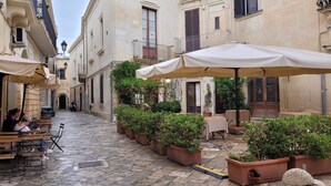 A courtyard with outdoor seating, potted plants, and a stone floor. - "Nuova Villa Ulivo" among olive and almond trees with private swimming pool (Carovigno)