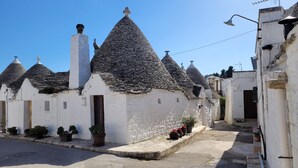 A row of traditional stone-roofed buildings with white walls and small windows. - "Nuova Villa Ulivo" among olive and almond trees with private swimming pool (Carovigno)