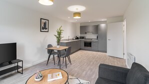 A modern apartment with a dining area, a living room, and a kitchen.