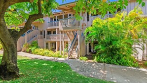 A multi-story building with balconies and a central staircase. - Kauai Nihi Kai Villas 507 2 Bedroom Condo (Koloa)