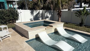 A swimming pool with two slides and a small seating area.