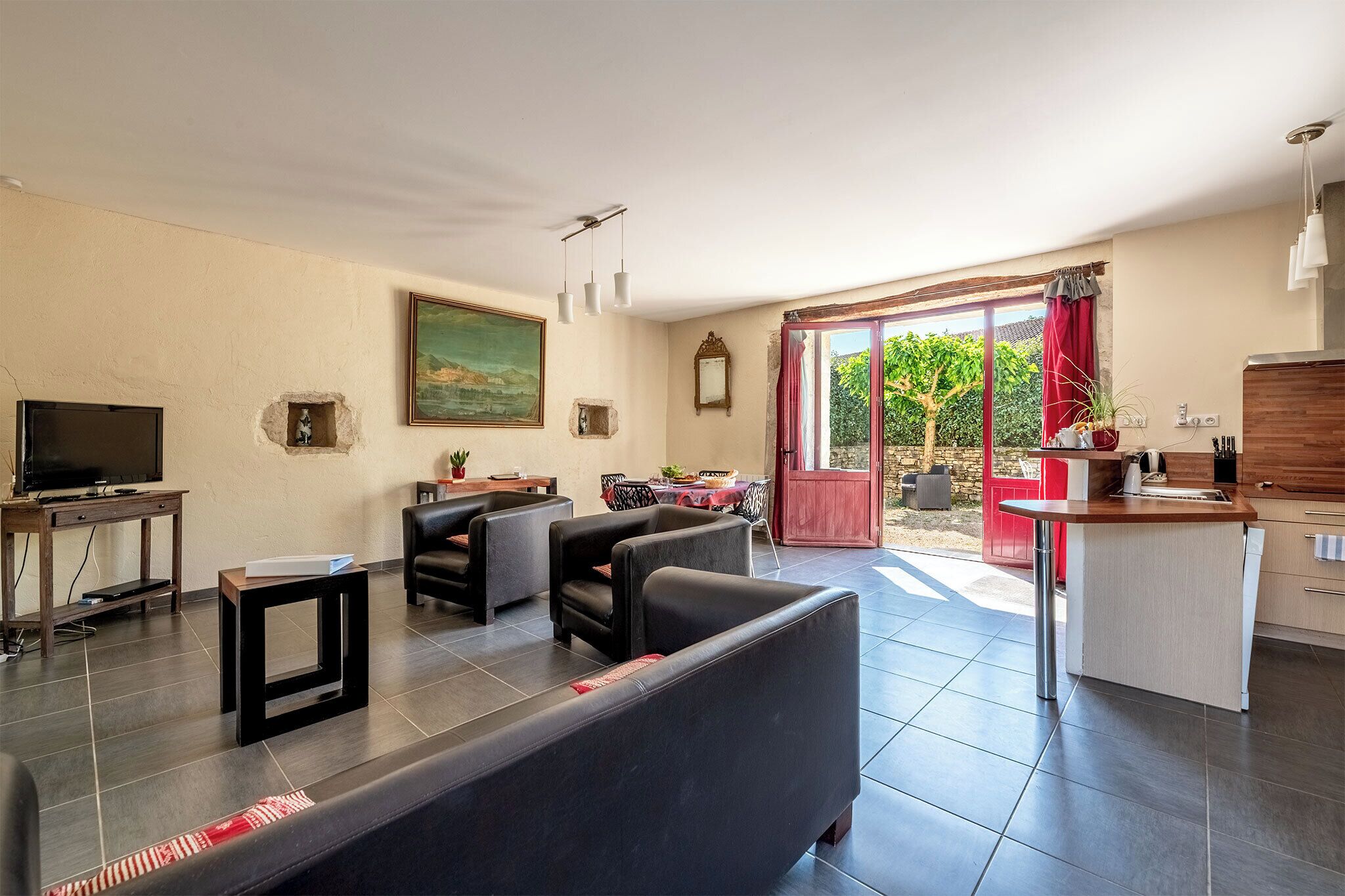 Ein Wohnzimmer mit Sofa, Fernseher und Essbereich mit Tisch und Stühlen.