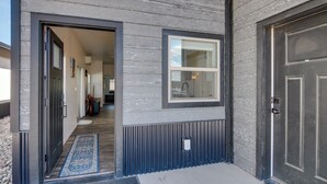 A modern building entrance with a wooden exterior, a blue patterned mat, and a door with a keyhole. - Lakefront Pagosa Springs Escape Near Hiking Trails (Pagosa Springs)