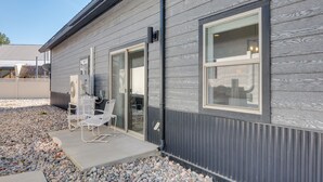 A modern building with a grey exterior, large windows, and a patio area with outdoor seating. - Lakefront Pagosa Springs Escape Near Hiking Trails (Pagosa Springs)