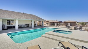 Piscina con lettini e una zona patio coperta.