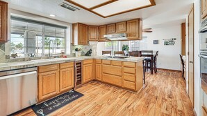 Una cucina con mobili in legno, forno a incasso e una grande finestra.