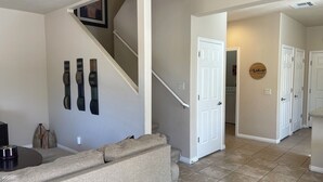 A home interior with a staircase, a living room area, and a kitchen. - Lucky Seven Oasis by Mesquite Vacation Rentals with Community Pool and $510 in free daily activities (Mesquite)