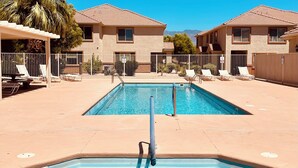 A swimming pool area with two pools, lounge chairs, and a covered seating area. - Lucky Seven Oasis by Mesquite Vacation Rentals with Community Pool and $510 in free daily activities (Mesquite)