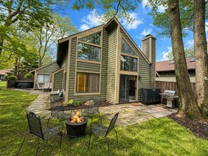 A modern house with a patio, outdoor seating, and a fire pit.