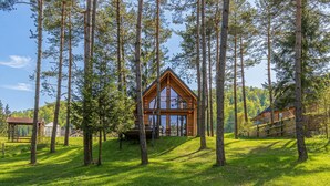 Una baita circondata da alti pini, con vista sulla foresta circostante.