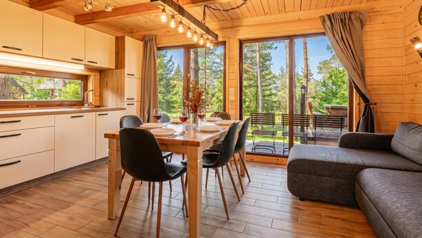 Un interno in legno con zona pranzo, cucina e divano.