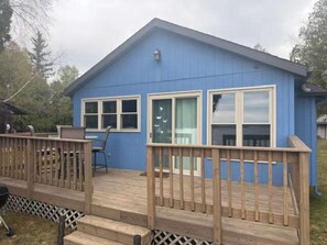 Ein blaues Gebäude mit einer Terrasse, Fenstern und einer Tür.