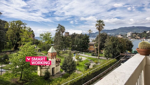 A view of a park with a tower, a body of water, and buildings in the background. - Sea View Flat in Rapallo by Wonderful Italy (Rapallo)