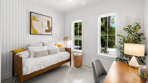 A bedroom with a bed, bedside table, lamp, and window.