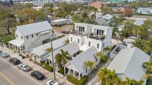 A residential area with houses, parked cars, and palm trees.
