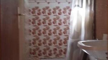 Een douche, handdoeken, toiletpapier