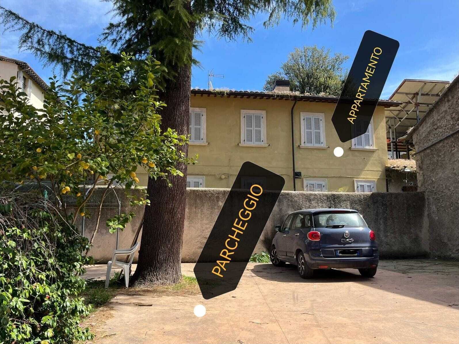 Une voiture est garée dans une allée, avec un bâtiment en arrière-plan.
