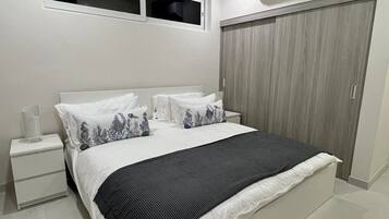 Una camera da letto con un letto, comodini, un armadio e un condizionatore.