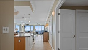 A spacious kitchen with a central island, large windows, and a view of the ocean. - Mustique 802- Luxury Condo with Direct Gulf View a (Gulf Shores)