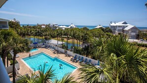 A pool area with a view of the ocean, surrounded by palm trees and a white fence. - Gulf View, Community Pool, Tennis, Beach Access (Santa Rosa Beach)